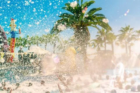 Foam pool party, bubbles blower and crowded pool with people swimmng, dancing Stock Photos