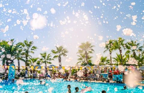Foam pool party, bubbles blower and pool with people swimmng, dancing, relaxing Stock Photos