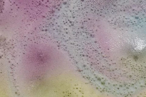 Foam produced by bath bombs creates colorful spacy background plate Stock Photos