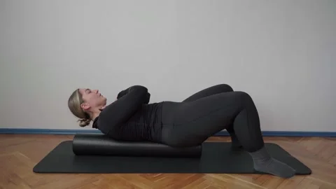 Foam Roller Thoracic Spine Massage on Mat in Simple Indoor Room Stock Footage 340544935