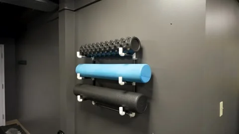 Foam rollers and recovery tools mounted on wall in studio gym Stock Footage 330620681