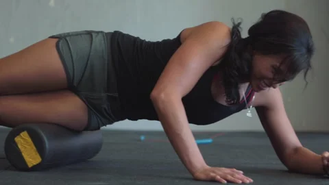 Foam rolling techniques for athletes in gym to aid muscle recovery Stock Footage 312757485