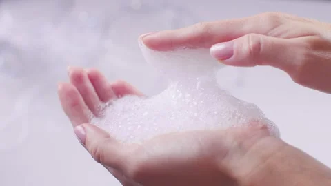 Foam from shampoo on hands on a white background beautiful close-up 動画素材 258321657