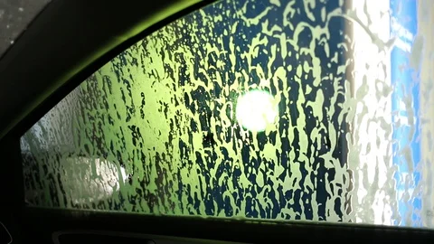 Foam streams flow down the side of the car in the car wash Stock Footage 129709947