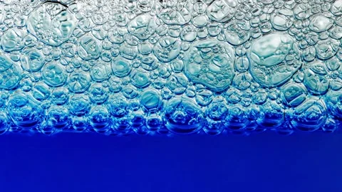 Foam on surface of liquid blue detergent, bubbles different size 库存影片 240647015