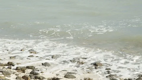 Foam wave and over the beach has stone Stock Footage 128943189