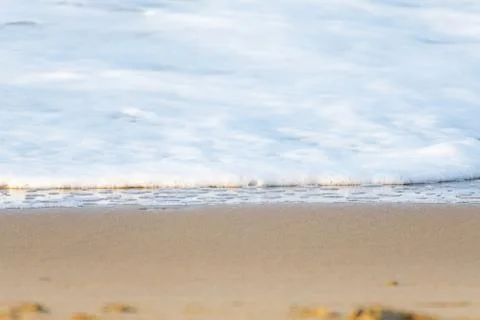 The foam of a wave reaching the sandy coast Foto stock