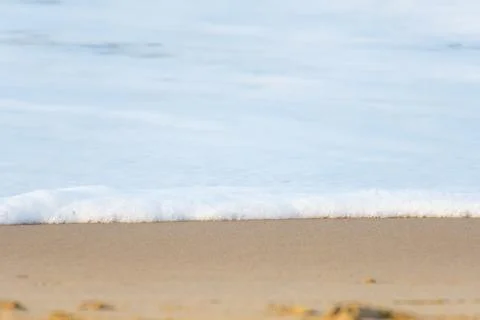 The foam of a wave reaching the sandy coast Stock Photos