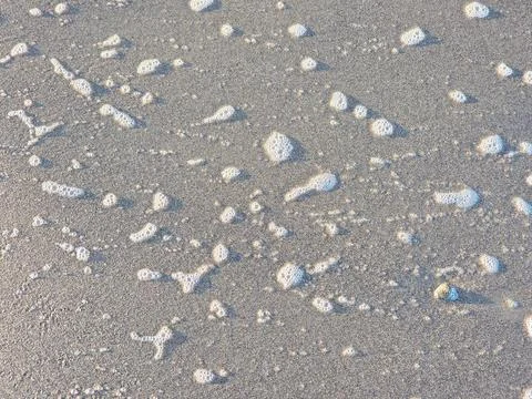 Foam waves on the beach sand Stock Photos