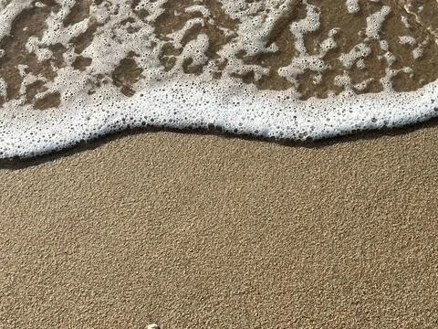 Foam on the waves on the sand Stock-Fotos