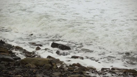 Foam waves on stony shore slow mo Stock Footage 81965581
