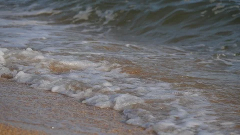 Foam waves wash over the shell beach. Video stock 120652005
