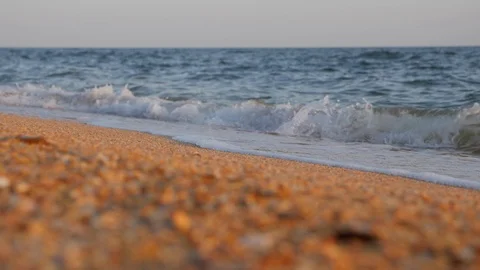 Foam waves wash over the shell beach. Stock Footage 123796386