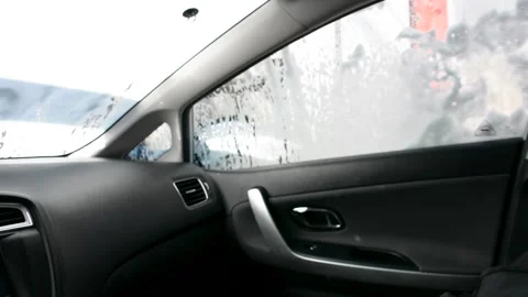 Foam on the windshield. Washing the dirt from the machine with foam. View from c Vidéo 161157599