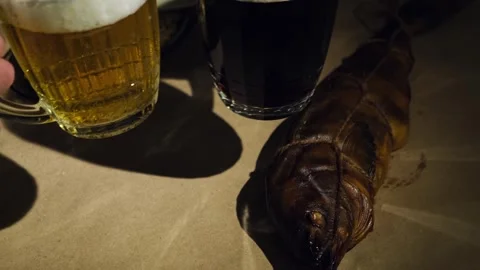Foaming dark and light beer poured in mugs and fresh smoked fish, close-up. Stock Footage 258813169