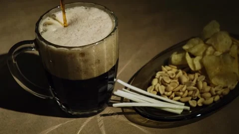 Foaming dark beer and snacks, close-up. Stock Footage 258813102