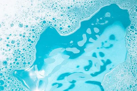 Foaming Detergent Bubbles and Turquoise Water. Texture background Stock Photos