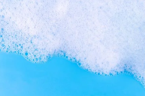 Foaming liquid on blue backdrop. Cosmetics foam background. Cosmetic produc.. Stock Photos