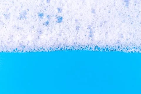 Foaming liquid on blue backdrop. Cosmetics foam background. Cosmetic produc.. Foto stock