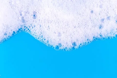 Foaming liquid on blue backdrop. Cosmetics foam background. Cosmetic produc.. Stock Photos