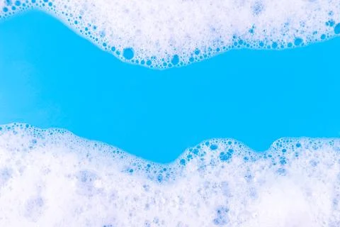 Foaming liquid on blue backdrop. Cosmetics foam background. Cosmetic produc.. Stock Photos