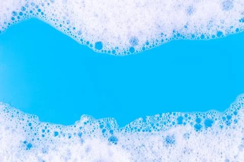 Foaming liquid on blue backdrop. Cosmetics foam background. Cosmetic produc.. Stock Photos