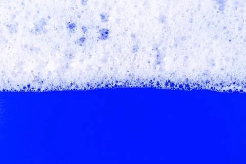 Foaming liquid on blue backdrop. Cosmetics foam background. Cosmetic produc.. Stock Photos