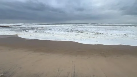 Foaming sea waves coming in and withdrawing leaving patterns of foam. Stock Footage 325185795