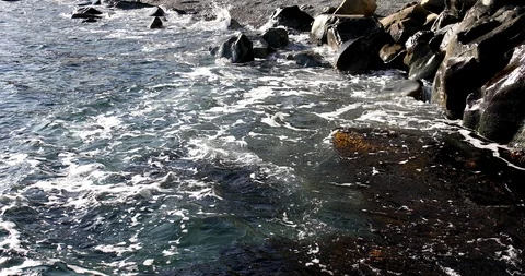 Foaming splashing background of sea waves near a rocky shore in sunny weather 動画素材 122245947