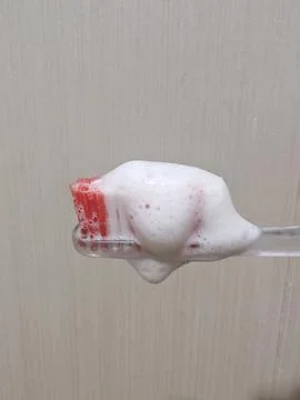 Foaming Toothpaste on Red Bristle Toothbrush Stock Photos