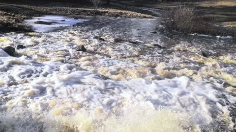 A foaming waterfall turning into a fast-flowing river. With sound. Stock Footage 151550783