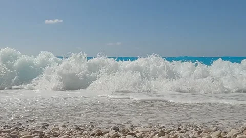 Foaming wave splashing on the beach and hitting the camera. Slow motion. Stock Footage 316878372