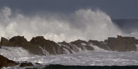 Foaming waves crashing over a narrow finger of a rocky reef Stock Footage 59525444