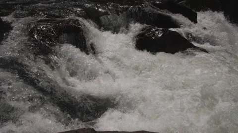 Foaming whitewater and black rocks in a river Stock Footage 59528103