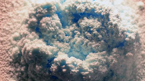 Foamy, abstract blue cloud like structures are formed by a powder spray Stock Footage 97706101