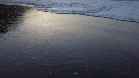 Foamy atlantic ocean wave slowly moving towards camera on volcanic beach during Video stock 123045352