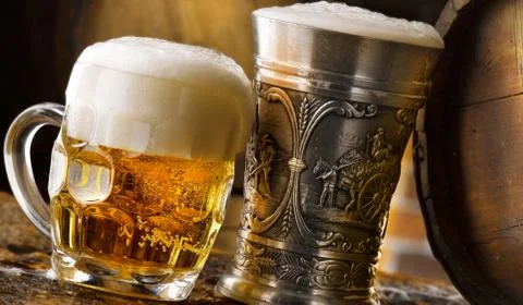 Foamy beer mugs set in rustic cellar Stock Photos