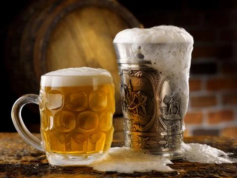Foamy beer mugs set in rustic cellar Stock Photos