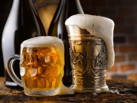 Foamy beer mugs set in rustic cellar Stock Photos