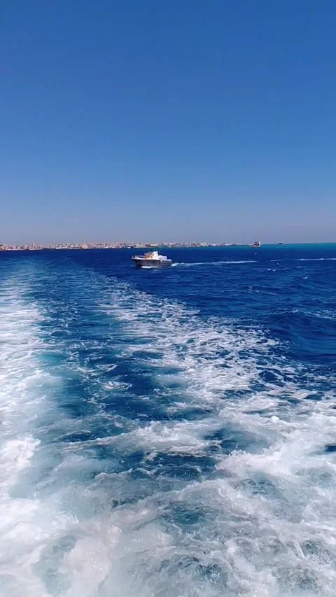 Foamy boat wake in deep blue sea with motorboat and Hurghada coast 스톡 동영상 341314716