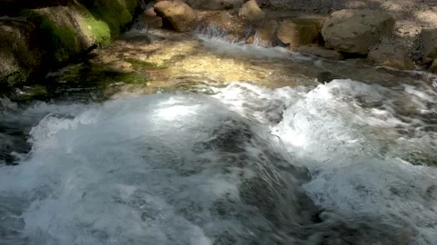 Foamy mountain stream. Close-up of clear cold water flows in a rocky river. Video stock 140862584