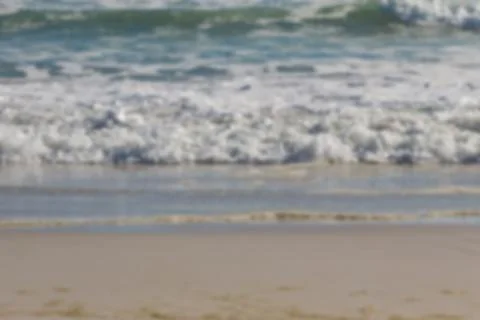 Foamy ocean waves are rolling onto sandy shore in flat design, highlighting Stock Photos