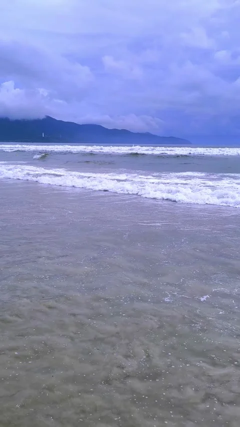 Foamy Ocean Waves Crashing Under a Dramatic Overcast Sky Stock Footage 319348114