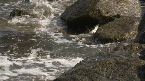 Foamy ocean waves hitting rocks on shore Stock Footage 117752898
