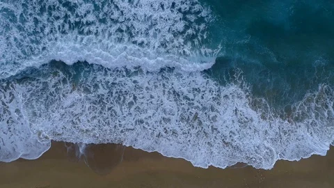 Foamy ocean waves rolling and coming on a sand beach. Aerial top down shot, 4K Stock Footage 103429960