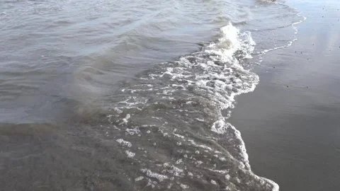 Foamy sea waves rolling onto the sandy beach. Stock Footage 301945040