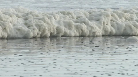 Foamy storm wave rolls on beach. Video stock 137895010