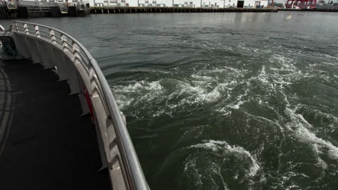 Foamy trail and bubbles from the ferry engine. Docks and freight cranes. NYC 動画素材 200042042