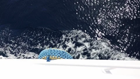 Foamy trail glides along deep navy sea as yacht slices through shimmering water  Stock Footage 310818759