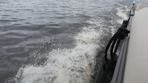Foamy wake alongside moving boat on lake Vídeo Stock 344828809